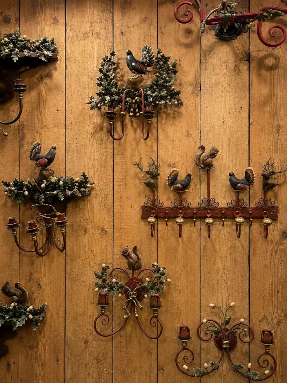 A wall of hand-wrought iron sconces and ornaments shaped like alpine birds and game