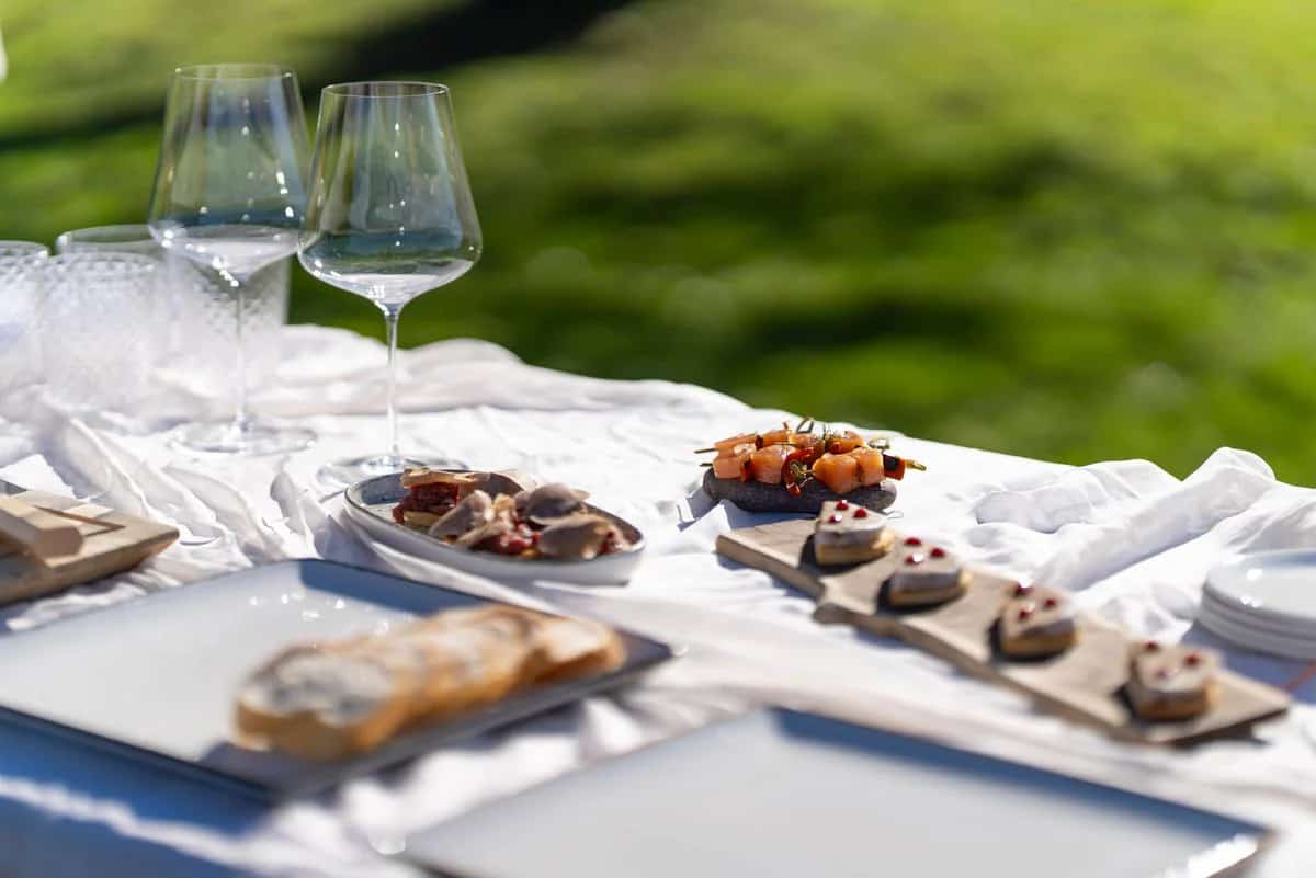 An open-air aperitivo laid on white linen in an alpine meadow