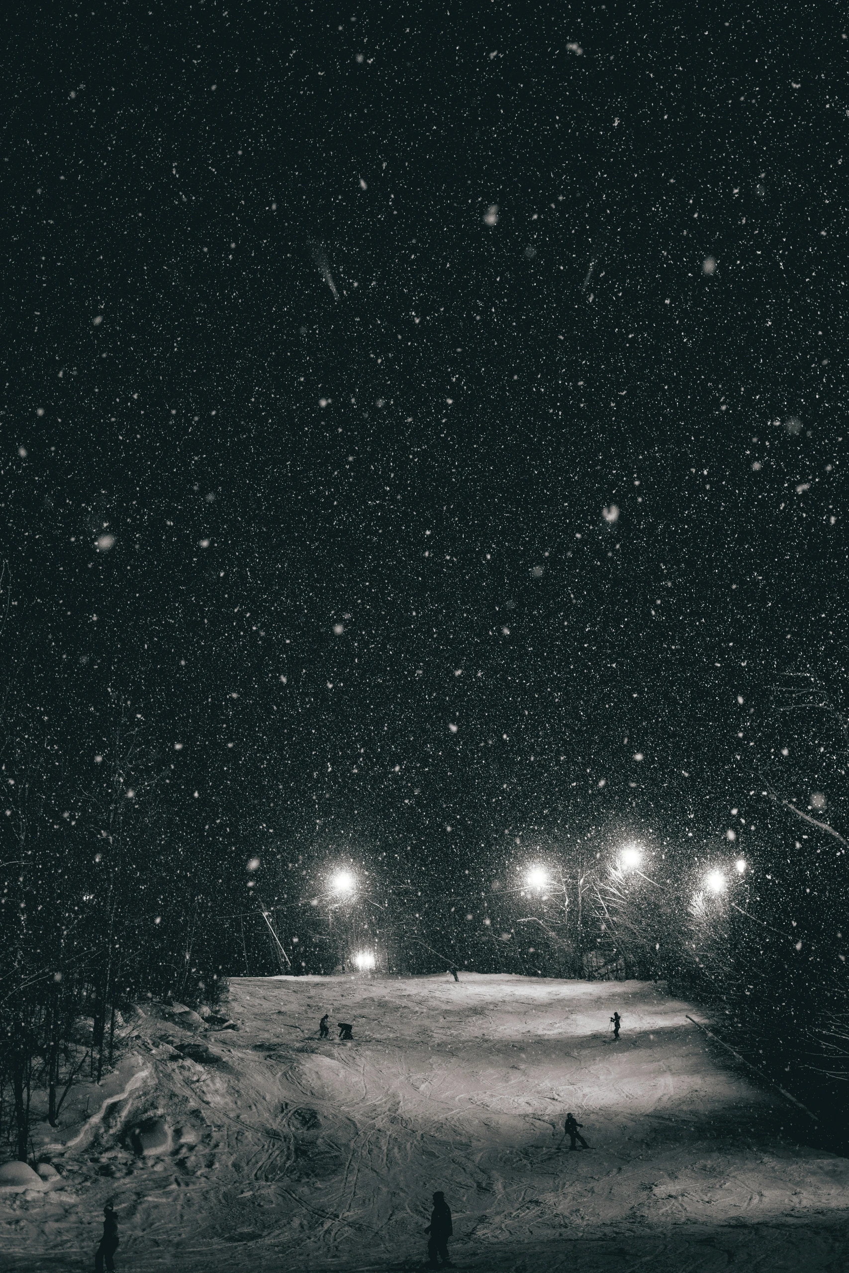 Illuminated ski slopes beneath a star-filled winter sky